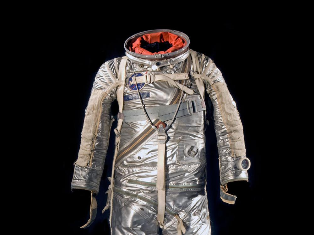 Silver-coated, full-body flight suit with various spots for tubes to be placed. 