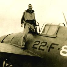 Person standing on the wing of a vintage military aircraft marked with '22 F 8'.