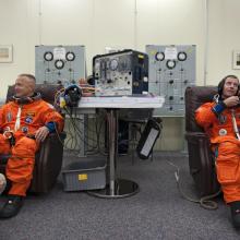 astronauts in orange flight suits